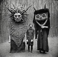 two people standing next to each other with monster heads on their faces and one person wearing a costume