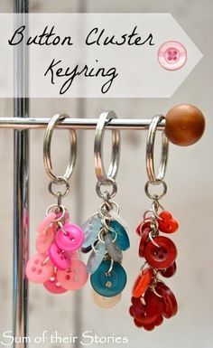 the button clusterer keyring is hanging from a metal rack with four different buttons attached to it