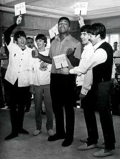 black and white photograph of men holding up signs in front of their faces while standing next to each other