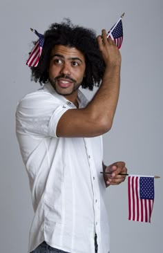 a man with an afro holding two american flags