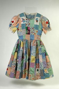 Patchwork dress, 1942 - V&A Museum of Childhood Victoria and Albert Museum Made for child by her mother the night b4 a last minute party invitation. Scrap Dress, Childhood Clothes, Childrens Outfits, Quilted Dress, Museum Of Childhood, Quilted Clothing, Names Girl, Interesting Story