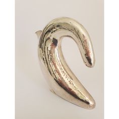 a metal object that is shaped like a snake's tail, on a white surface