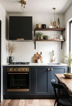 a kitchen with dark blue cabinets and gold accents on the counters, shelves above the stove