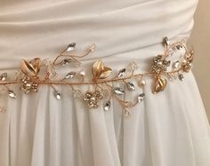 Whimsical nature, This delicate floral vine is hand wired with luminous pearls, sparkling crystals and delicate stamped gold metal leaves. Daintily rimming your waist, this bridal sash is eye catching and and very feminine.  MADE TO ORDER, Please allow 3-4 weeks to complete your order. DETAILS * Measures aprox. 1.75' wide (at widest part by 14" long. * Lightweight, flexible & very comfortable *  Attached at ends to imported  French satin ribbon in color choices * Offerend in gold * Total sash le Elegant Bridal Belt With Flower Decoration For Wedding, Bridesmaid Belt, Crystal Wedding Tiaras, Pearl Wedding Dress, Flower Girl Accessories, Waist Jewelry, Gold Wedding Dress, Wedding Dress Sash, Vine Wedding