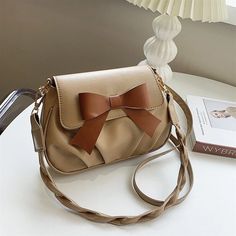 Elegant Beige Shoulder Bag with Brown Bow Chic Beige Satchel For Gift, Chic Brown Shoulder Bag For Gift, Chic Brown Shoulder Bag As Gift, Chic Beige Satchel As Gift, Elegant Brown Flap Bag For Gift, Elegant Brown Flap Bag As Gift, Elegant Beige Bag With Bow, Elegant Crossbody Shoulder Bag With Bow, Beige Crossbody Flap Bag Gift