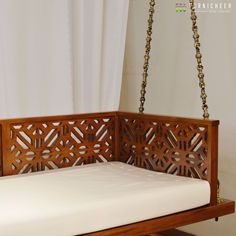 a wooden bench with a white mattress on it's side and a chain hanging from the ceiling