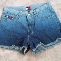 Vintage Ombre Denim Large Patch Jean Shorts Denim Shorts From Tommy Jeans, Made In Usa. In Excellent Condition With One Small Spot Below Right Front Pocket That Appears To Be A Dye Lot Variation - It Is Faintly Lighter In Color - Appear Unworn Otherwise. Set On Waist, Loops Front Zip & Button Closure Front Scoop & Rear Patch Pockets Large Hilfiger Logo Patch At Rear Waist Raw Leg Hems Size 5 - Approx Measurements Flat, & Unstretched: Waist 14" Hip 19" Front Rise 10" Inseam 2.5" Ombre Denim, Patched Jeans, Shorts Denim, Tommy Jeans, Front Pocket, Patch Logo, Patch Pocket, Jean Shorts, Vintage 90s