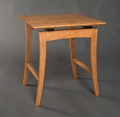 a small wooden table sitting on top of a gray floor