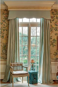 a living room filled with furniture next to a window covered in curtains and drapes