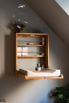 a shelf with towels and other items hanging from it's sides in a room