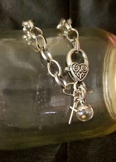 "Faith Bracelet - Mustard Seed and Cross with Heart Clasp  (Matthew 17:20) Beautiful circle loop chain bracelet with gorgeous heart lobster clasp,  plus two hanging charms:  a mini-globe with a mustard seed within and a small silver-toned cross.  Details:  Bracelet: *8.26 inches/ 21cm-22cm, circle link 10.5x8mm, clasp 25x14mm.   *modifiable lengths/links  Silver toned, lead free, alloy metal loop chain.  Mustard Seed Pendant Charm: A real mustard seed is within glass globe.   Globe size is 10mm Spiritual Chain Bracelet With Lobster Clasp As Gift, Heart-shaped Metal Charm Bracelet For Friendship, Silver Dangle Bracelets With Heart Charm, Silver Heart Charm Dangle Bracelet, Silver Charm Bracelet With Heart Charm For Friendship, Charm Dangle Bracelet With Adjustable Chain, Spiritual Metal Chain Bracelet With Lobster Clasp, Gift Charm Bracelet With Adjustable Dangle Chain, Dangle Charm Bracelet With Adjustable Chain For Gift