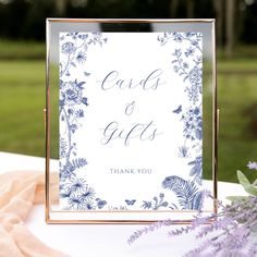 a sign that says cards and gifts on top of a table with flowers in the background