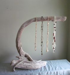 a branch with beads hanging from it on top of a white bed in a room