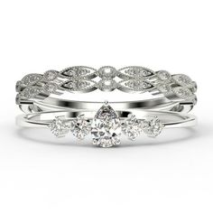 three pieces of white gold and diamond wedding ring set with an oval shaped center stone