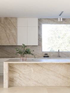 a modern kitchen with marble counter tops and white cabinetry is pictured in this image