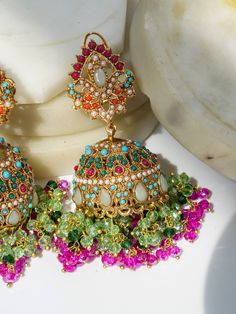 Discover the must-have Aamina - Matte Gold Plated Multicolor Jhumka Earrings, perfect for any Navratan jewelry enthusiast. With four stunning color choices of gold plating and zircon stones, these jhumka earrings are a charming addition to any collection. Specifications: Earring Type: Jhumka Earrings Color Choices: Matte Gold/Pink Matte Gold/Sage Green Matte Gold/Dark Green Matte Gold/Golden Material: High-quality gold plating Pure brass filling Earring Spec: Length: 3 inches Backing: Push-back Elegant Handmade Multicolor Jhumkas, Luxury Multicolor Festive Jhumkas, Elegant Multicolor Cutdana Jhumkas, Festive Multicolor Jhumkas, Traditional Multicolor Ceremonial Jhumkas, Ear Chain, Chandbali Earrings, Accessories Ear, Ethnic Looks