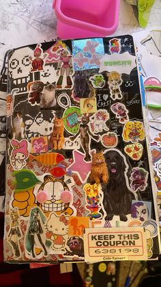 a bunch of stickers sitting on top of a table next to a pink container