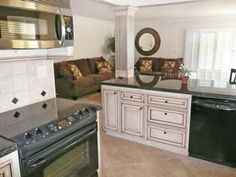 a kitchen with white cabinets and black appliances