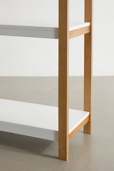 a wooden shelf sitting on top of a white floor