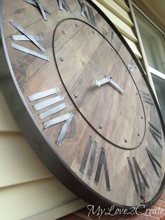 a large metal clock on the side of a building with roman numerals and numbers