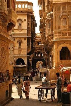 people are walking through an old city street