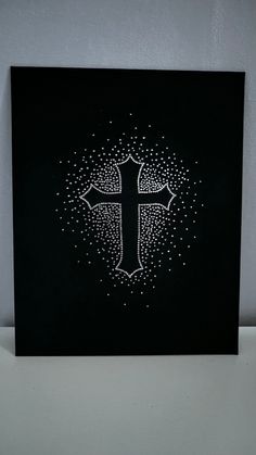 a black and white painting with a cross on it's side, surrounded by small dots