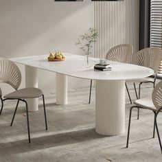 a white table with four chairs around it and a vase on the table next to it