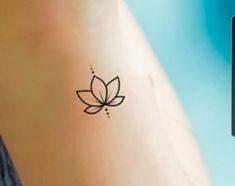 a small tattoo on the side of a woman's arm with a flower in it