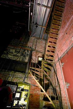 an old brick building with stairs leading up to the top floor and second story door