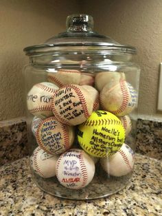 a glass jar filled with baseballs on top of a counter