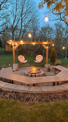 an outdoor fire pit with swings and lights