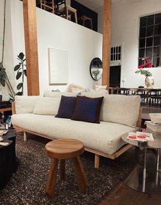 a living room filled with furniture and lots of wood flooring next to a white wall