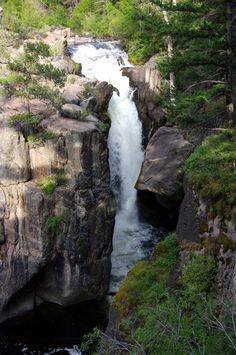 a large waterfall is coming out of the rocks