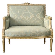 an ornately decorated chair with gold trimmings and blue upholstered fabric