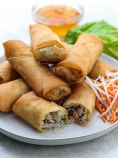 a white plate topped with vegetable spring rolls