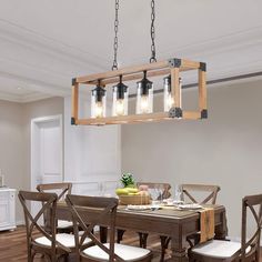 a dining room table and chairs with lights hanging from the ceiling