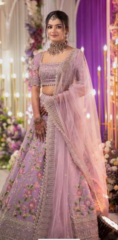 a woman in a pink lehenga with flowers on it