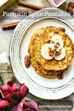 two pancakes with bananas and pecans on a white plate next to some cinnamon sticks