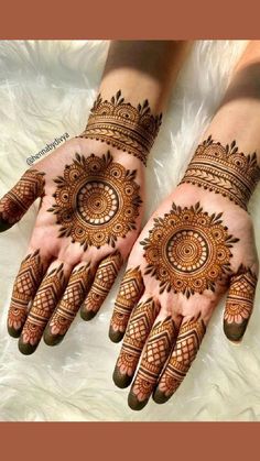 two hands with henna tattoos on them, one is showing the intricate pattern and the other