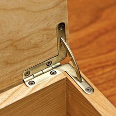 an open wooden cabinet door with metal hinges