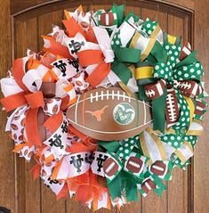 a football wreath on the front door with orange, white and green streamers around it