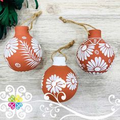 two orange and white vases sitting on top of a wooden table