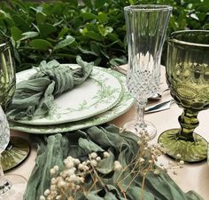 a table topped with green glassware and plates