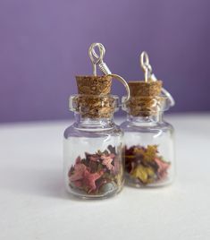 two small glass jars filled with different colored leaves