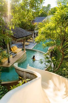 a person swimming in a pool surrounded by trees