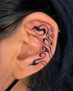 a close up of a person's ear with some tattoos on their left side