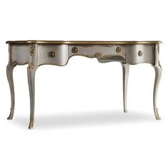 an antique white and gold desk with drawers