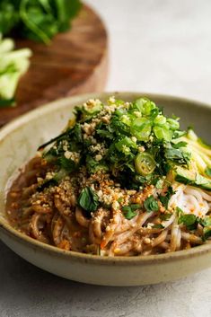 a bowl filled with noodles and vegetables on top of a table