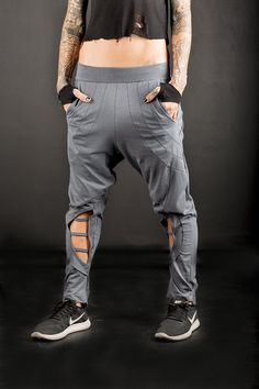 Urban low crotch Baggy Trousers/Cyberpunk women's low crotch pants/post apocalyptic baggy pants/Futuristic low crotch pants Baggy low waist pants. Decorated with stitching at the back and asymmetric ending . Pockets and big openings with straps at the front,calves exposing. Made of cotton Lycra and elastic at the waist fits better on many body types. A necessary piece for those sworn to street-fashion! A pair of pants that stands out,no need to make any effort for your appearance with this desig Baggy Cotton Bottoms For Cosplay, Baggy Techwear Harem Pants, Techwear Harem Pants, Baggy Techwear Pants For Alternative Fashion, Baggy Drop Crotch Bottoms For Festival, Futuristic Pants, Hose Post, Low Crotch Pants, Pantalon Baggy