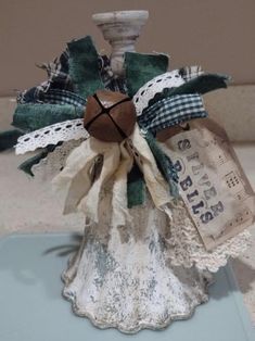 an old fashioned candle holder is decorated with fabric